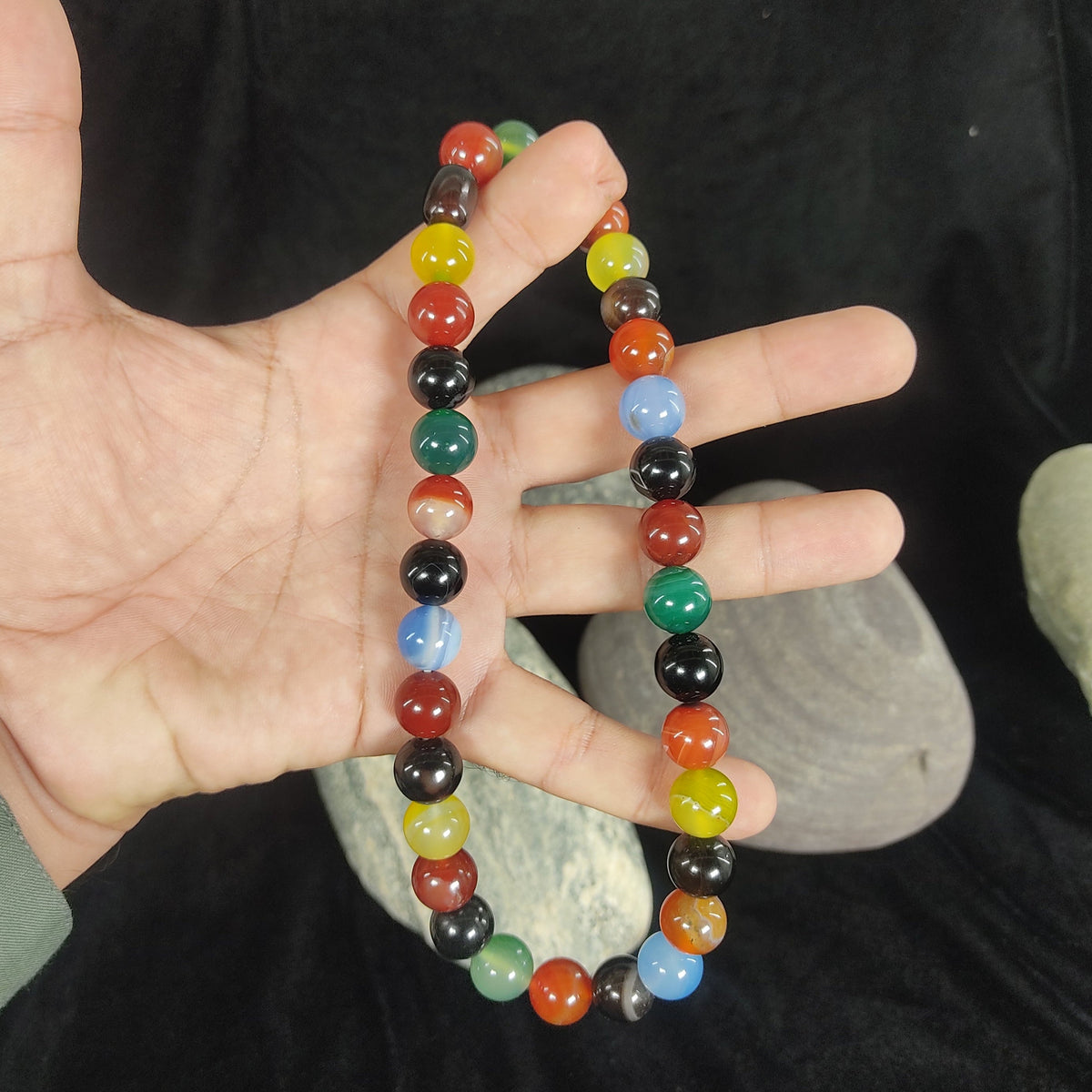 Multicolored beaded bracelet on a hand with a dark background